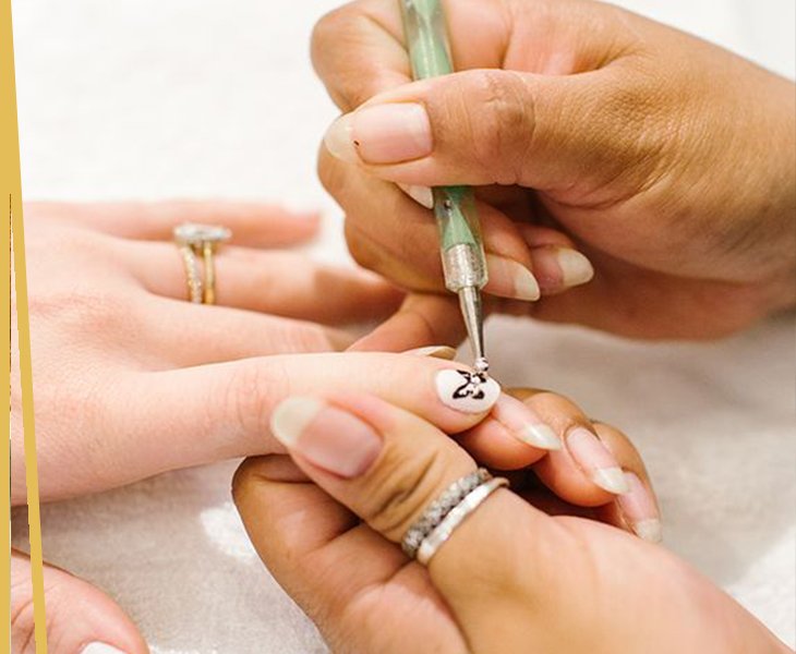 Detailed nail art being painted at Page 3 Salon